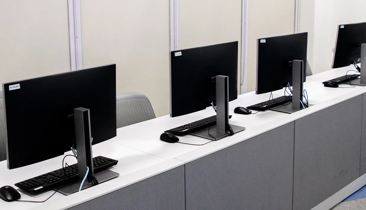 Row of desktop computers on work counters, illustrating trackable shared equipment